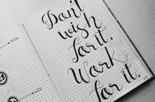 Close-up of motivational calligraphy on grid paper, inspiring message for productivity.